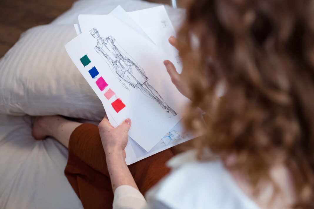 Projektantka ocenia szkice i próbki tkanin przy biurku