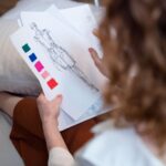 Projektantka ocenia szkice i próbki tkanin przy biurku