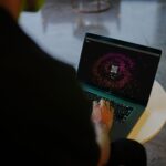 Osoba korzysta z laptopa z kolorowym kodem QR w nowoczesnym wnętrzu