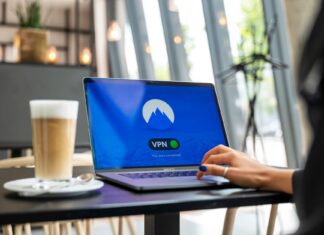 Osoba z laptopem z włączonym VPN w nowoczesnej kawiarni