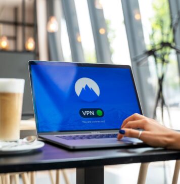 Osoba z laptopem z włączonym VPN w nowoczesnej kawiarni