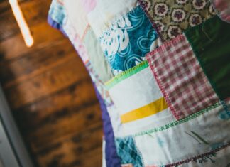 Patchwork jako pamiętnik rodziny: co mówią stare kołdry zszywane z resztek tkanin Zbliżenie na kolorową kołdrę patchworkową z różnymi wzorami i fakturami