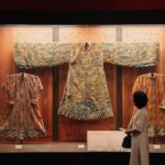Tradycyjne chińskie szaty w muzeum oglądane przez zwiedzającego