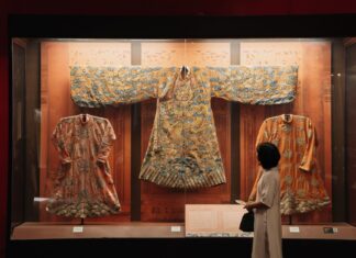Tradycyjne chińskie szaty w muzeum oglądane przez zwiedzającego